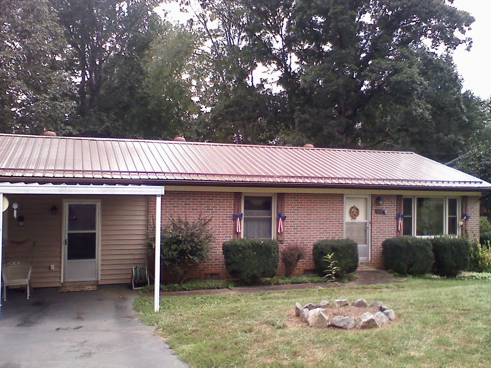 Bronze metal roof and carport on a brick ranch home — Roof Repair work by our crew in Loma Mar