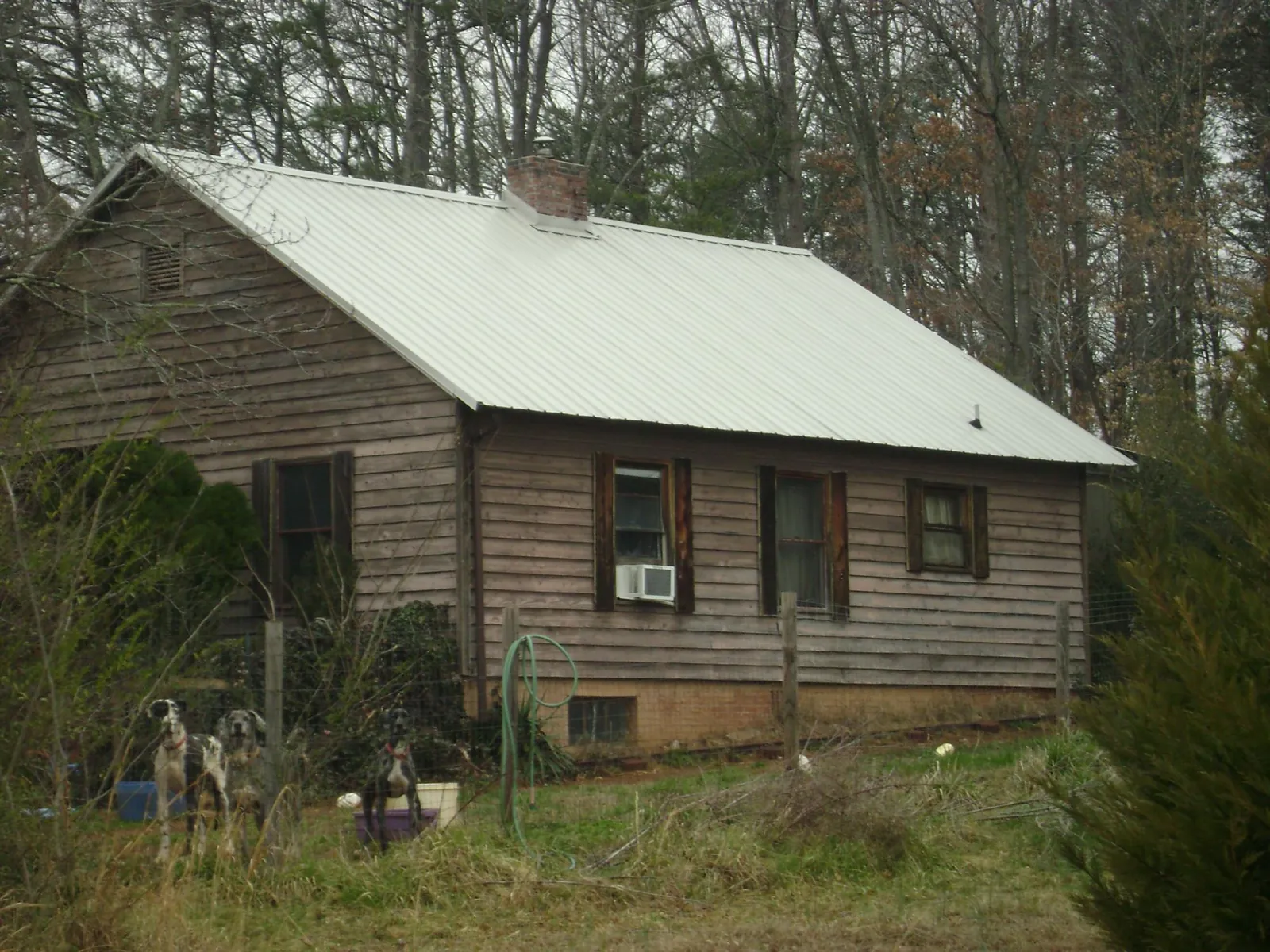 White metal roof on an old wood sided farmhouse, from a Metal Roof Installation job in Loma Mar